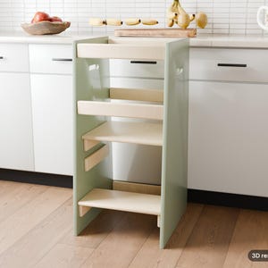 May include: A sage green wooden learning tower with a natural wood finish platform and safety rails. The structure features a step at the base and a standing platform, designed with side cutouts for handles and a sturdy frame construction.