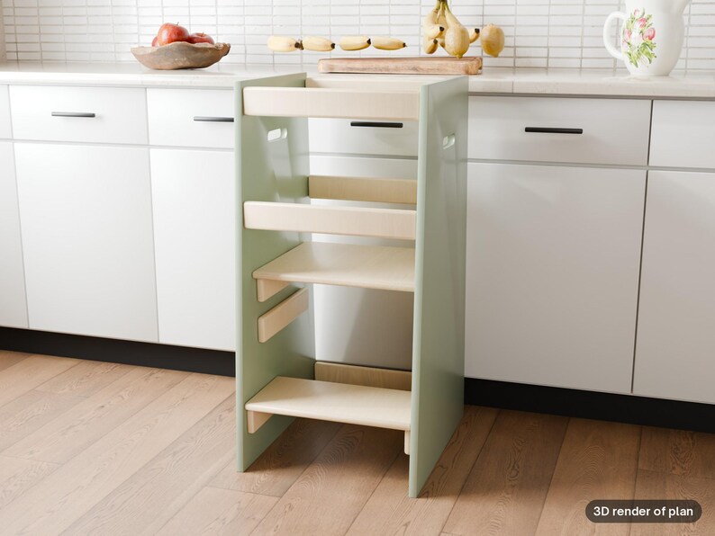 May include: A sage green wooden learning tower with a natural wood finish platform and safety rails. The structure features a step at the base and a standing platform, designed with side cutouts for handles and a sturdy frame construction.