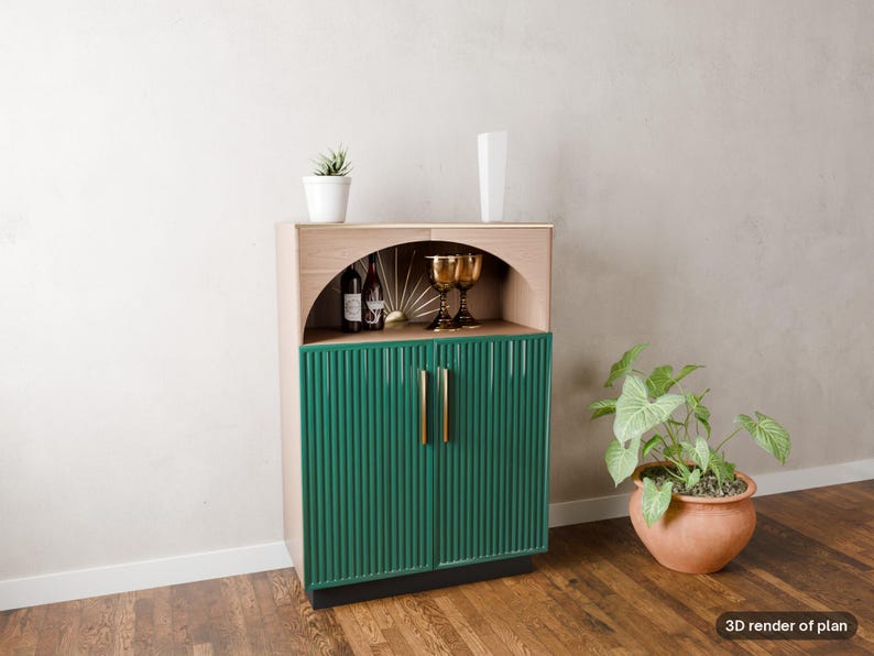 May include: A wooden cabinet featuring a light wood upper section with an arched open shelf and a lower section with two dark green fluted doors. The cabinet has gold vertical handles and contains two wine bottles and two gold goblets.
