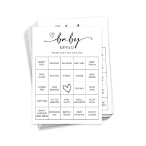 May include: A stack of black and white baby bingo cards. The cards have a heart with the word "baby" above it and the word "bingo" below it. The cards have a 5x5 grid with various baby-related items listed in each square. The text "The first to get five in a row wins" is printed below the bingo title.