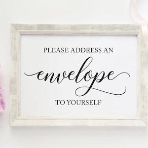 May include: White framed sign with the text "PLEASE ADDRESS AN envelope TO YOURSELF" in black calligraphy.