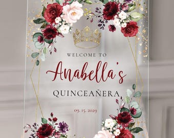 Könnte beinhalten: Klarer Acrylschild mit floralen und goldenen Akzenten. Auf dem Schild steht "Willkommen bei Anabella's Quinceañera" mit dem Datum 09.15.2029. Das Design umfasst burgunderrote, weiße und rosa Rosen, eine goldene Krone und Goldglitter.