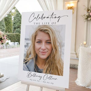 May include: A white sign on an easel with the text "Celebrating the Life of" above a photo of a woman with blonde hair and blue eyes. The name "Bethany Collier" and dates 03.02.23 - 09.22.29 are below the photo. The sign is at an outdoor event.
