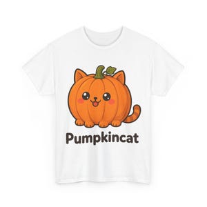 Op de afbeelding: Een wit T-shirt met korte mouwen en een centrale afbeelding van een ronde oranje pompoen in de vorm van een kat met een groene steel, kleine oortjes, een staart en een lachend gezicht. Onder de afbeelding staat de tekst Pumpkincat in donkerbruin.