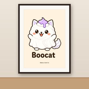 May include: A framed wall art print featuring a white cartoon cat dressed as a ghost with a purple dollop of frosting on its head. The text Boocat is printed in dark brown below the cat, with the smaller text Bakery Cats Co underneath.