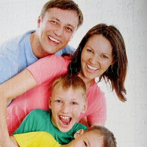 A personalized puzzle gift that is from a photo and made into a puzzle with 60 pieces.  This personalized puzzle is vertical and has a family of four smiling at the camera.