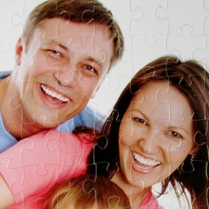 Personalized photo puzzle of a family of four wearing colorful clothing and all are smiling - The Missing Piece Puzzle Company