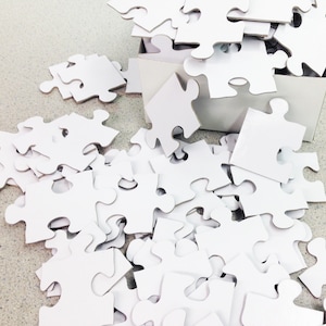Handnummerierte weiße Puzzleteile für Hochzeitsgästebücher auf der Rückseite nummeriert. Leere Puzzleteile für Hochzeitspuzzle.