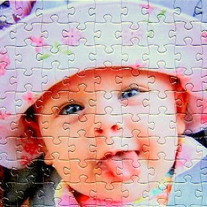 custom photo puzzle made from your picture.  Little girl wearing pink hat.  Personalized puzzle of child sticking tongue out.