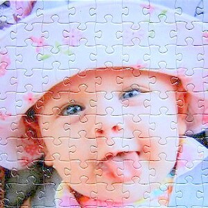 custom photo puzzle of a young baby wearing a pink hat with flowers.  Baby is sticking tongue out while smiling - The Missing Piece Puzzle Company