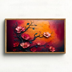 Puede incluir: Una obra de arte enmarcada que presenta un árbol estilizado con flores rosas sobre un fondo vibrante. Las ramas son oscuras y las flores tienen una apariencia texturizada. El fondo transita del naranja al rojo intenso.