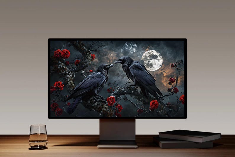 May include: A computer monitor displays a digital art piece featuring two black ravens perched on a branch with red roses. A full moon shines in the background. The scene is set against a dark, cloudy sky.