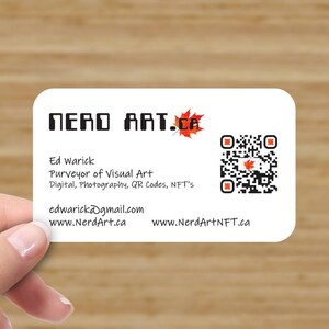 May include: A white business card with rounded corners featuring the text "NERD ART.CA" in black. The card includes contact information, a QR code, and a maple leaf graphic. The card is held by a person.