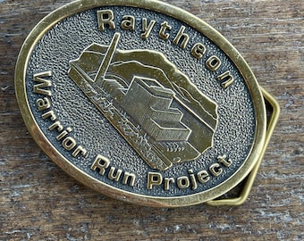 Vintage Raytheon Warrior Run Project energy belt buckle advertising brass colored belt buckle 1991