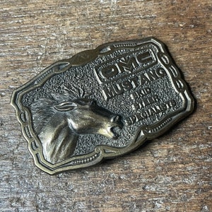 Vintage OMC Mustang Skid Steer Specialists Tractor Farm Equipment Advertising brass colored belt buckle