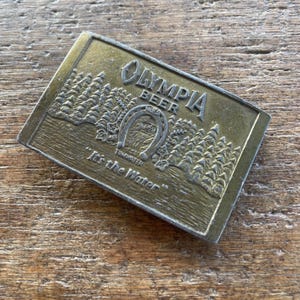 Vintage buckle Olympia Beer It’s in the Water Beer Brass colored belt buckle