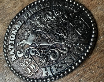 Vintage belt buckle National Finals Rodeo Heston 1984 raised design brass colored Limited Collectors Edition Fred Fellows belt buckle