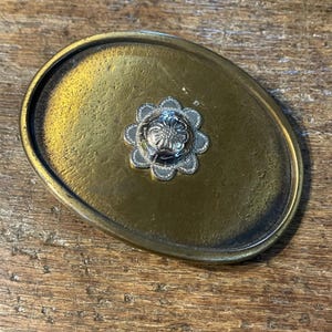 Silver colored textured flower Brass colored belt buckle