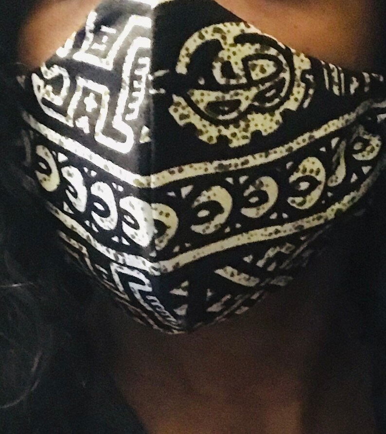 May include: Black and white face mask with a geometric pattern. The pattern features a repeating design of circles and lines.