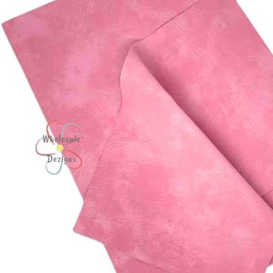 May include: Three sheets of pink faux leather with a subtle marbled texture. The sheets are stacked on top of each other.