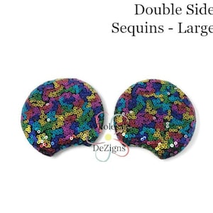 May include: Two circular ear-shaped accessories covered in multicolored sequins. The text above reads Double Sided Sequins - Large 3.3 inches. The sequins feature a vibrant mix of blue, green, yellow, and purple tones across the rounded surfaces.