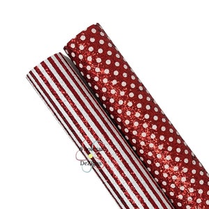 May include: Two rolls of glittery faux leather. One roll is red with white stripes, and the other is red with white polka dots. The rolls are angled towards the upper right corner, with the striped roll in front.