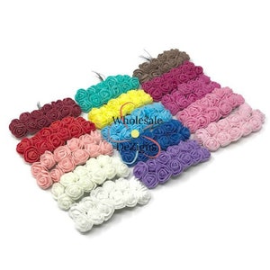 May include: Assortment of 12 colors of small foam rose flower heads. Each flower head is approximately 1 inch in diameter. The flower heads are arranged in rows, with each row containing a different color. The colors include red, pink, white, blue, purple, yellow, green, orange, brown, and black.