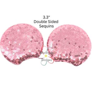 Peut inclure: Deux pièces de sequins roses à double face, chacune mesurant 8,4 cm de diamètre, sont présentées sur un fond blanc. Les sequins sont de couleur rose clair, avec un dégradé rose plus foncé en bas. Le texte au-dessus indique "3.3" Double Sided Sequins."