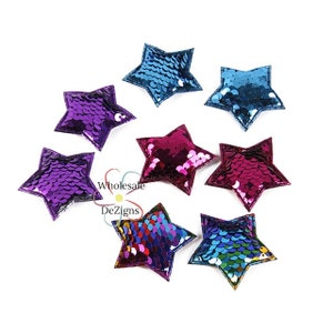 May include: A collection of sequined star-shaped patches in various colors, including purple, blue, and pink. The patches have a stitched border and a shiny, reflective surface. The image also includes the text "Wholesale DeZigns".