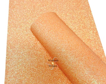 May include: A sheet of peach-coloured glitter fabric with iridescent shimmer. The fabric is folded in half and the brand name "Wholesale DeZigns" is visible in the lower right corner.