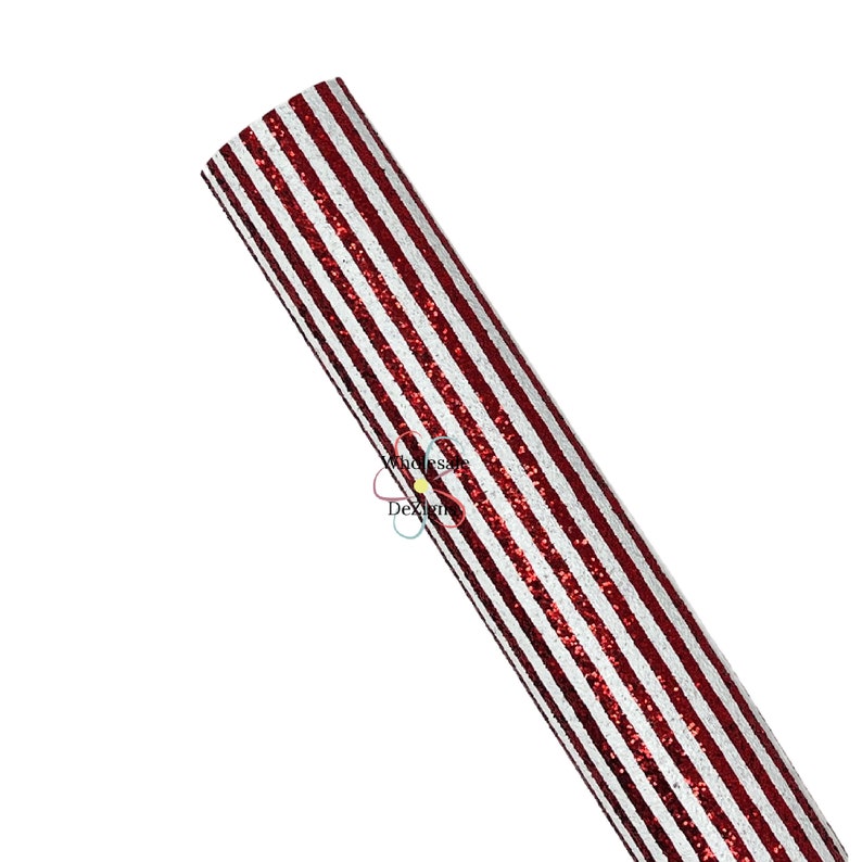 May include: A roll of red and white striped glitter fabric. The stripes are vertical and evenly spaced. The fabric is rolled up, showing the pattern on the surface. The glitter adds a sparkling effect to the material.