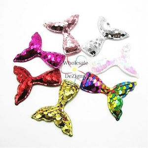 May include: Assortment of eight mermaid tail sequins in various colors, including pink, red, gold, white, and iridescent. The sequins are approximately 2 inches in length and are perfect for crafting projects.