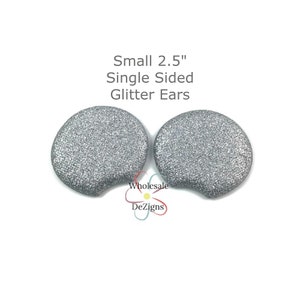 May include: Two 2.5 inch single-sided silver glitter ears. The ears are shaped like a rounded oval with a slight curve at the top.