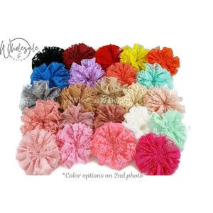 May include: A collection of circular lace fabric flowers in a wide variety of colors including black, red, yellow, orange, blue, purple, pink, white, and beige. Each flower features a ruffled, layered design with a delicate floral pattern.
