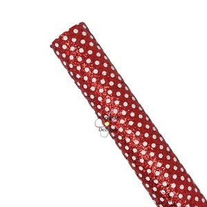 May include: A roll of red glitter fabric with a white polka dot design. The fabric is tightly rolled, showing the texture and sparkle of the material. The image is set against a white background.