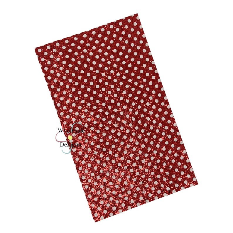 May include: A rectangular sheet of red glitter fabric with a white polka dot pattern. The fabric has a shiny, textured surface and is angled slightly. Suitable for crafts and DIY projects.