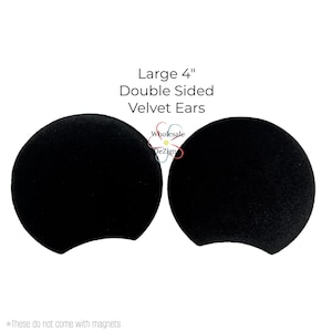 May include: Two black, double-sided velvet ears, each approximately 4 inches in diameter, are displayed against a white background. The text reads "Large 4" Double Sided Velvet Ears." The product is from Wholesale DeZign.