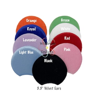 May include: A selection of 8.4 cm velvet ears in various colours: orange, royal blue, lavender, light blue, green, white, red, pink, and black. The text "Wholesale DeZigns" and "3.3" Velvet Ears" are visible.