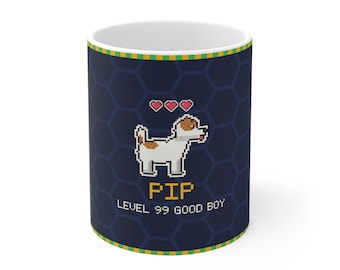 Puede incluir: Una taza de cerámica azul oscuro con un perro en arte de píxeles, tres iconos de corazones rojos, el texto amarillo PIP y el texto blanco LEVEL 99 GOOD BOY. La taza tiene un fondo de patrón hexagonal azul oscuro y bordes a rayas verdes y amarillas.