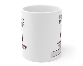 Puede incluir: Una taza de cerámica blanca con un gráfico de pixel art de una botella de poción llena de líquido marrón oscuro. El texto dice COFFEE POTION, RESTORES 100 HP, e incluye un pequeño icono de corazón rojo y destellos amarillos en la botella.