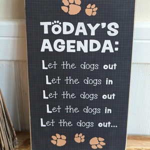 Wooden sign - schedule for a dog owner, let the dog in... let the dog out....!