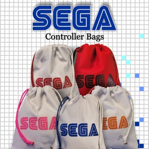 Könnte beinhalten: Fünf Kordelbeutel mit dem Sega-Logo in verschiedenen Farben. Die Beutel sind weiß mit dem Sega-Logo in Rot, Blau, Pink, Orange und Schwarz. Die Beutel sind in einem Halbkreis angeordnet, wobei das Sega-Logo zum Betrachter zeigt. Die Beutel sind mit "Sega Controller Bags" beschriftet.