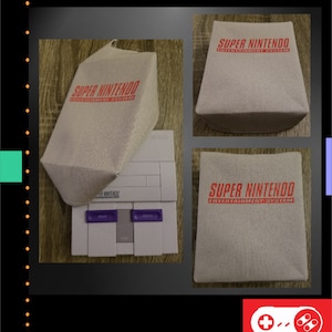 Op de afbeelding: Een lichtgrijze Super Nintendo Entertainment System-console met een bijpassende beschermhoes. De hoes en de console zijn voorzien van de woorden "Super Nintendo Entertainment System" in het rood. De console heeft paarse knoppen.