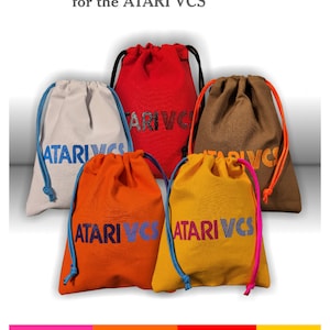 May include: Five fabric drawstring bags in white, red, brown, orange, and yellow, each featuring the text ATARI VCS. The bags have contrasting colored drawstrings. The image includes the text Handcrafted Controller Bags for the ATARI VCS.