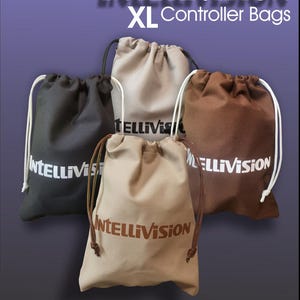 May include: Five drawstring bags in black, beige, light brown, and dark brown. Each bag features the word "Intellivision" printed on it in white or brown. These bags are designed for XL controller storage.