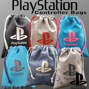 Puede incluir: Colección de bolsas con cordón para mandos, en varios colores, incluyendo negro, gris y azul. Cada bolsa presenta el logotipo de PlayStation y la palabra "PlayStation". Las bolsas tienen cordones para cerrar.