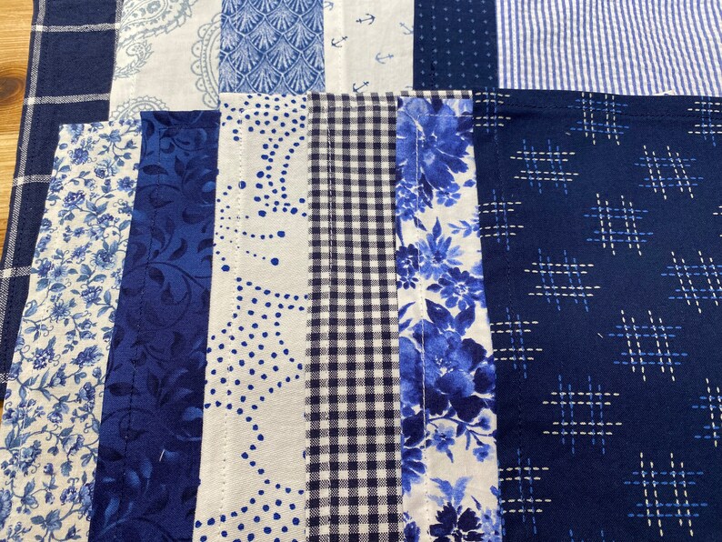 May include: A patchwork quilt with various blue and white patterns, including floral, geometric, and paisley designs. The quilt is made of different fabrics and textures, creating a unique and interesting look.