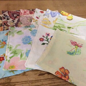 May include: A set of ten fabric napkins with floral patterns in various colors, including pink, blue, green, yellow, and white.