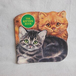 May include: A vintage children's book titled "The Kitten Book" featuring a close-up of two kittens. One kitten is orange and white, and the other is gray and white.