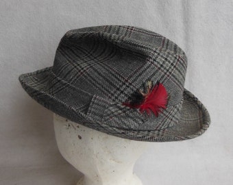 May include: A gray and red plaid fedora hat with a red feather accent.